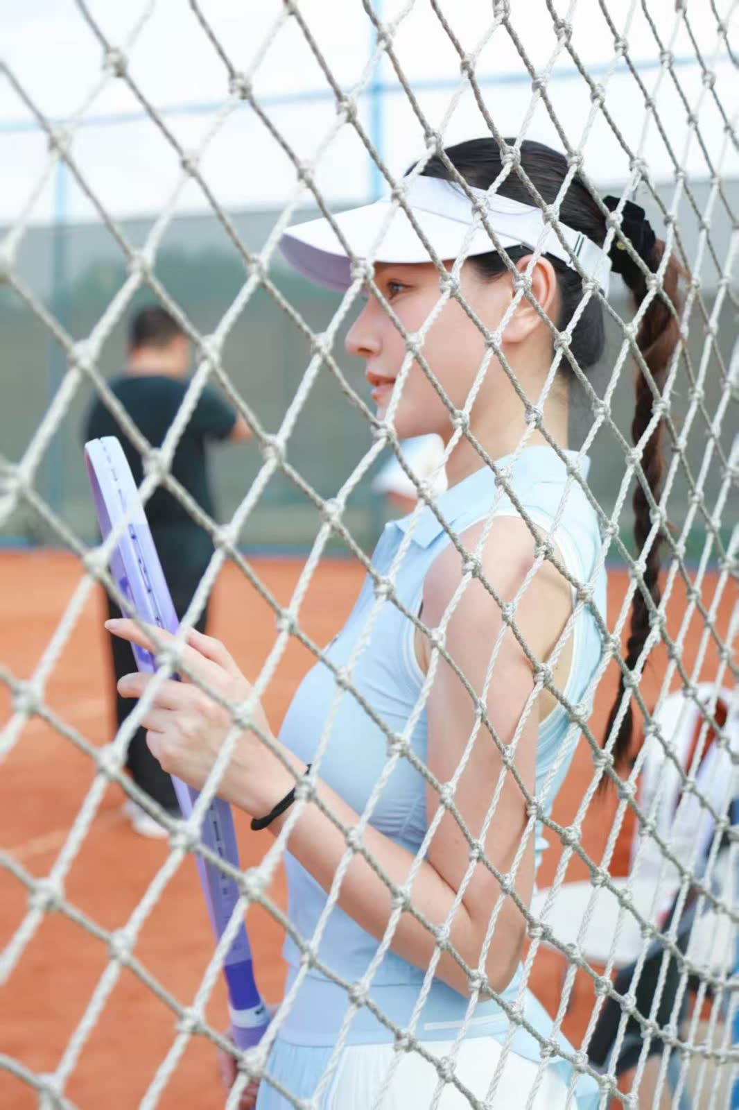 Side portrait behind a tennis net